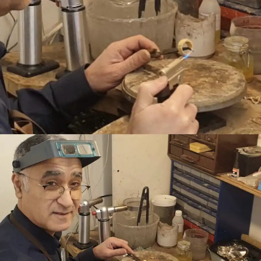 Två bilder av en äldre man i en smyckesverkstad. På den övre bilden håller han en ring med en pincett och använder en blåslampa för att bearbeta metallen. På den nedre bilden ler han mot kameran och bär förstoringsglas på huvudet, omgiven av verktyg och material på en arbetsbänk i en hantverksmiljö.