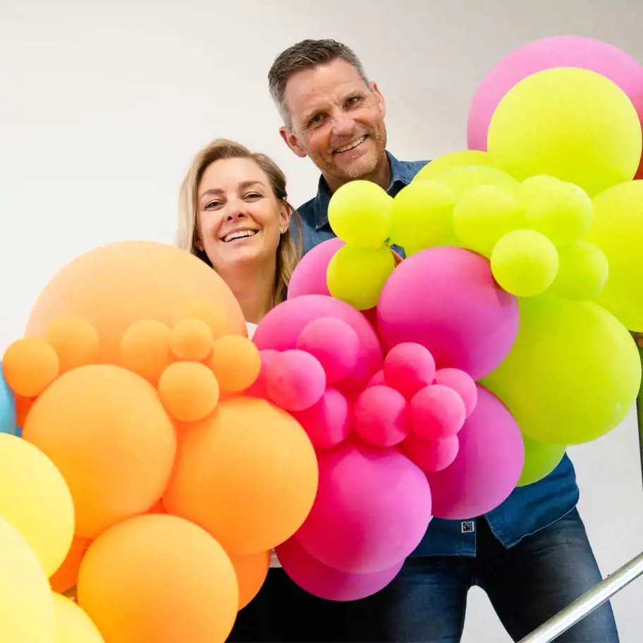 Helena Nilsson, rådgivare Almi, och Torbjörn Olsson, grundare av Ballongkungen, bakom en bukett av ballonger.