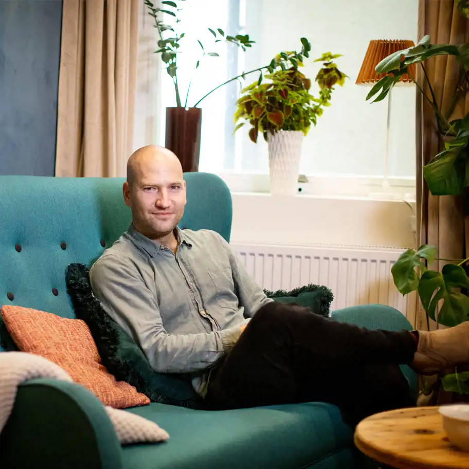 Simon Strandvik sitter i en soffa. 