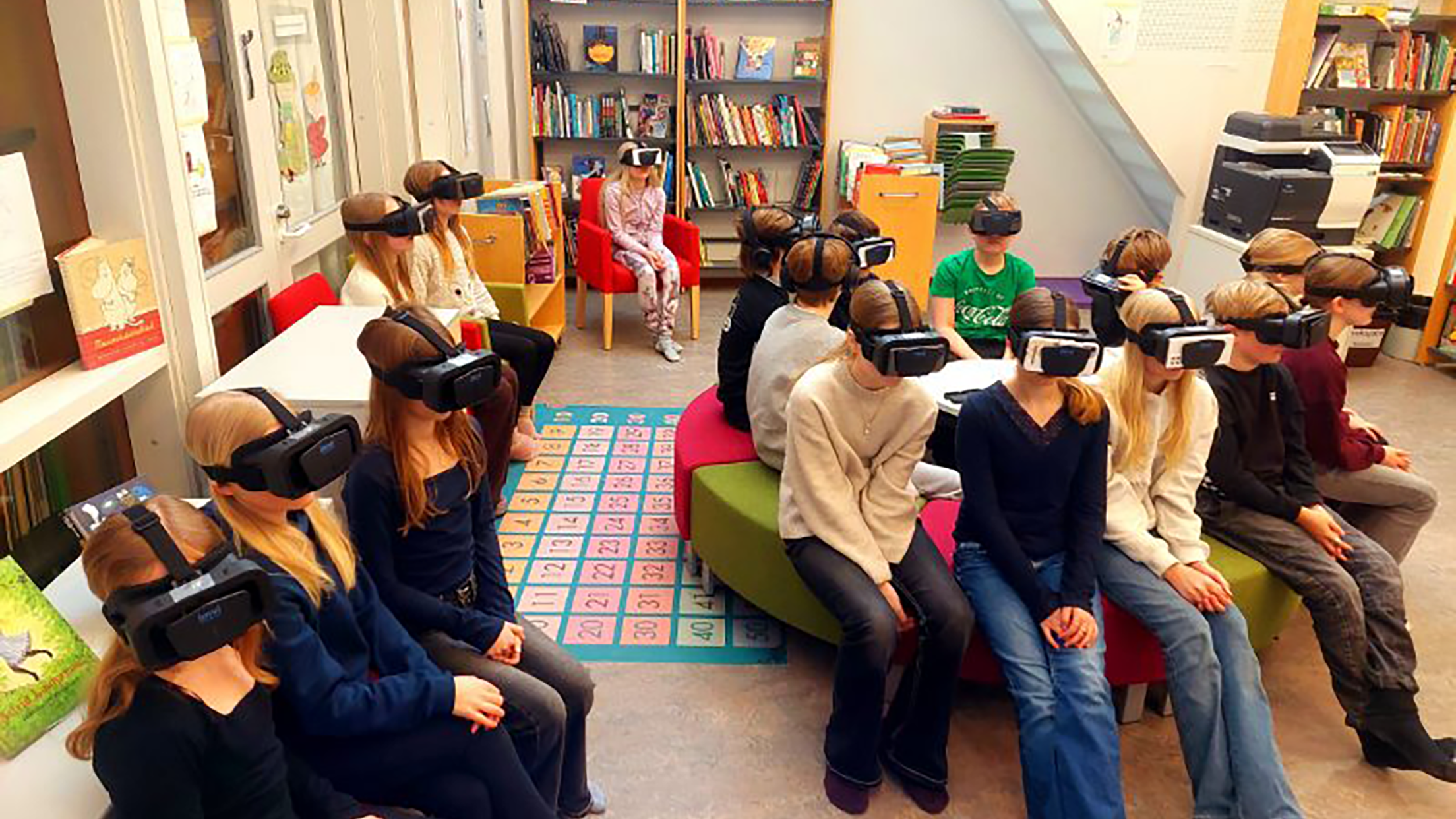 Skolelever sitter i ett klassrum och tränar med VR-glasögon från Imvi Labs för att förbättra sin ögonkoordination och läsförmåga.