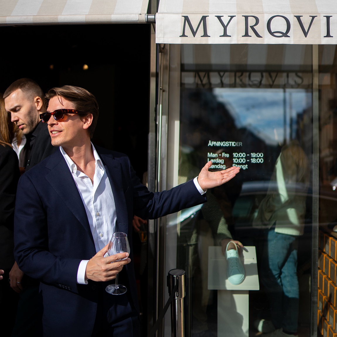 Sebastian Öhrn, vd och grundare av Myrqvist, står utanför butikens entré och pekar mot skyltfönstret.