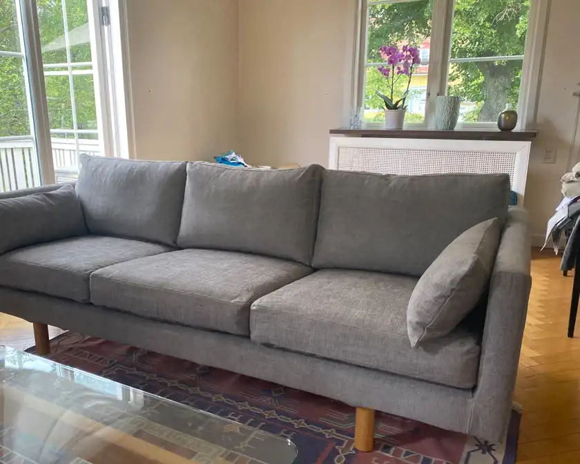 Efter-bild på en renoverad, grå soffa.