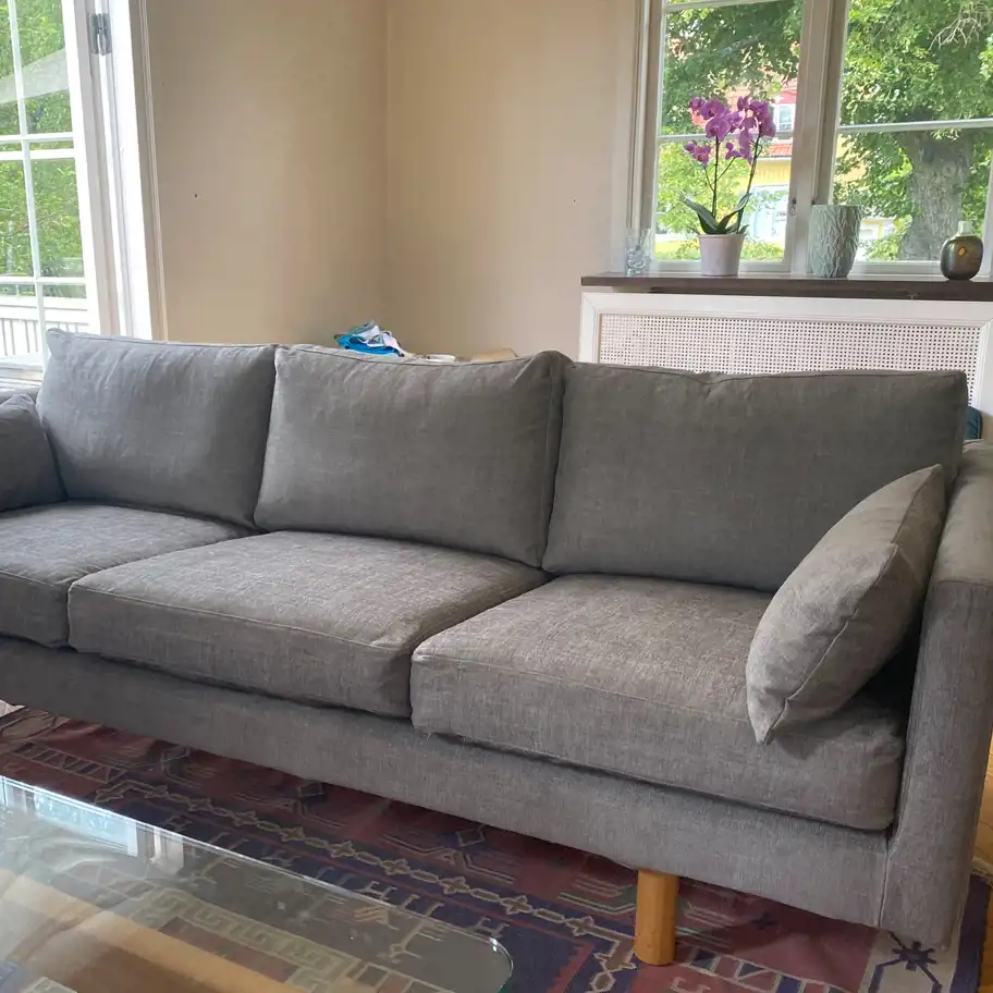 Efter-bild på en renoverad, grå soffa.