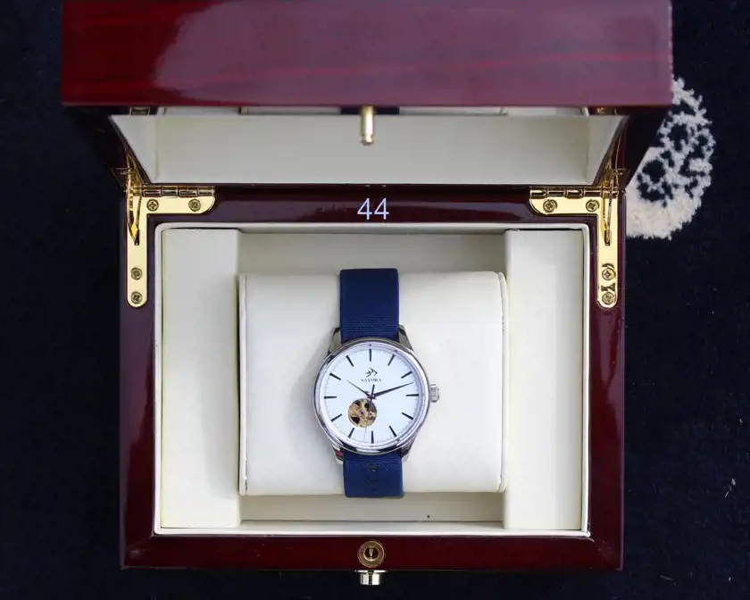 Armbandsklocka som ligger i en träaskförpackning.  