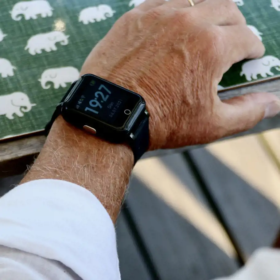 Närbild på en mans handled som bär Sensorems trygghetslarm.