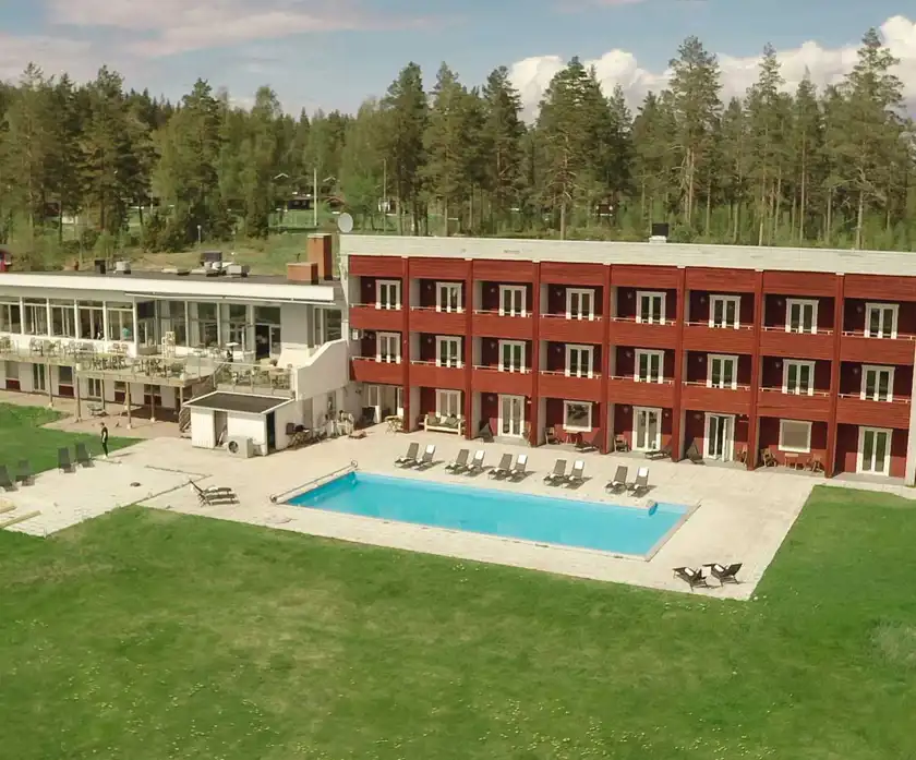 Flygfoto över hotellet med pool i förgrunden.