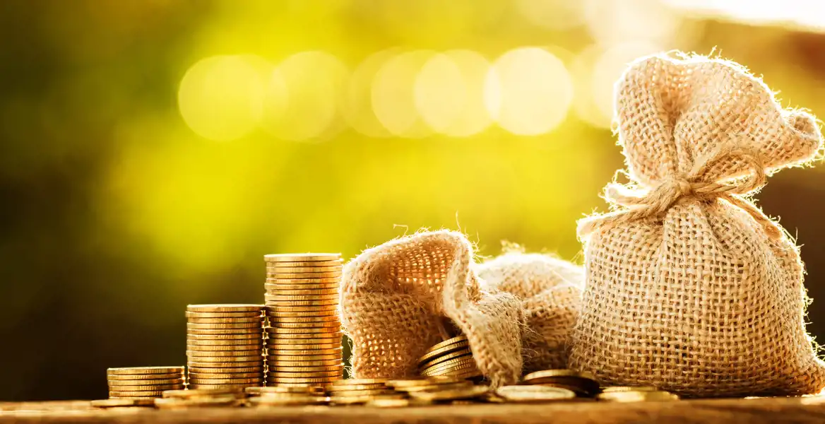 Travar av mynt och en säck med pengar.