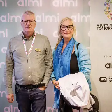 Personer som minglar framför en fotovägg.