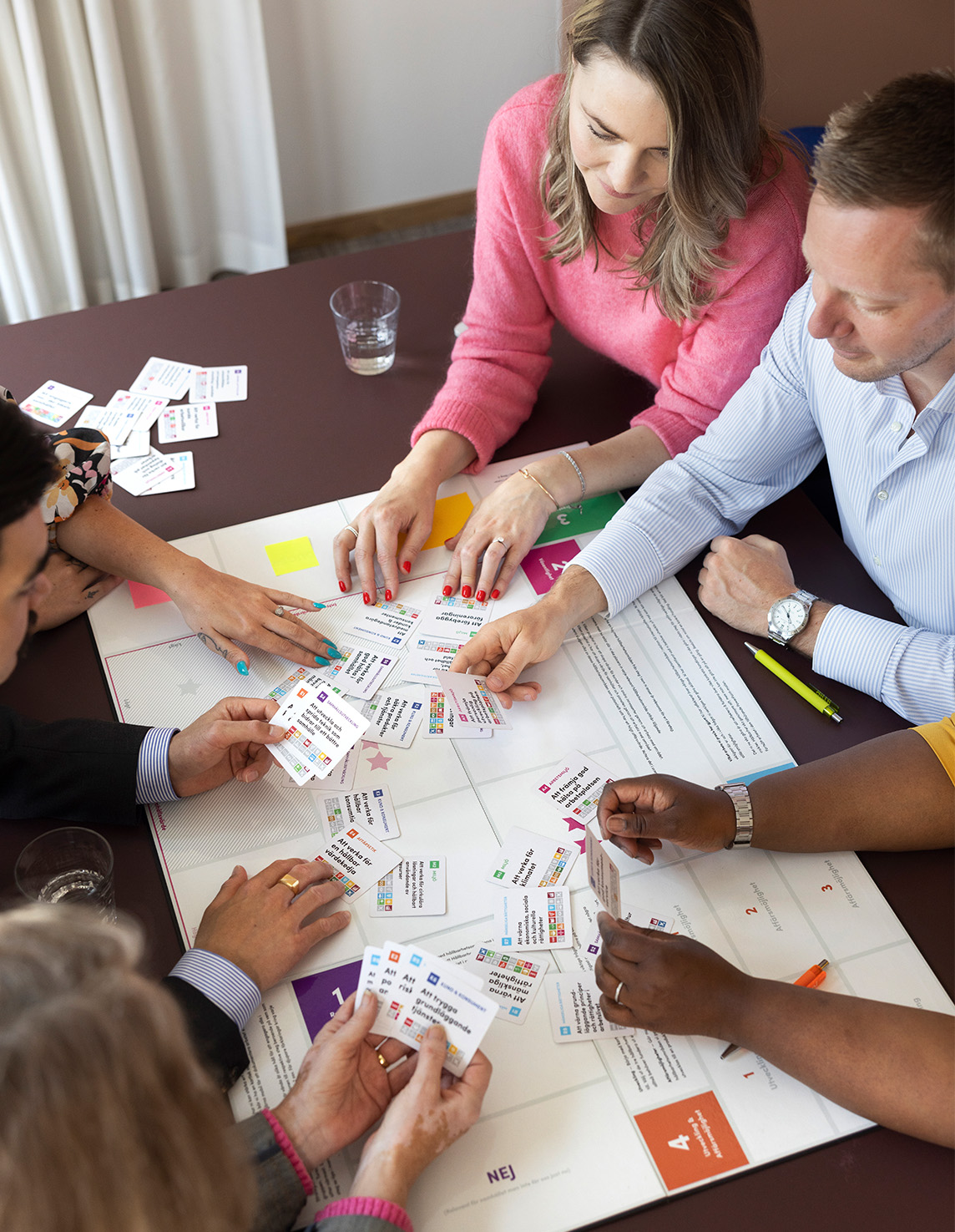 personer vid ett bord som spelar ett spel med tema hållbarhet