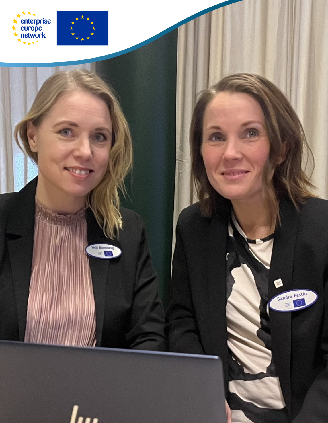 2 kvinnor i kavajer sitter vid datorn