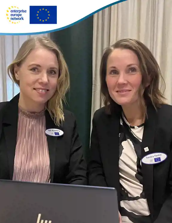 2 kvinnor i kavajer sitter vid datorn