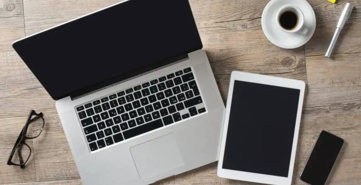dator, padda, mobil och en kopp kaffe på ett bord