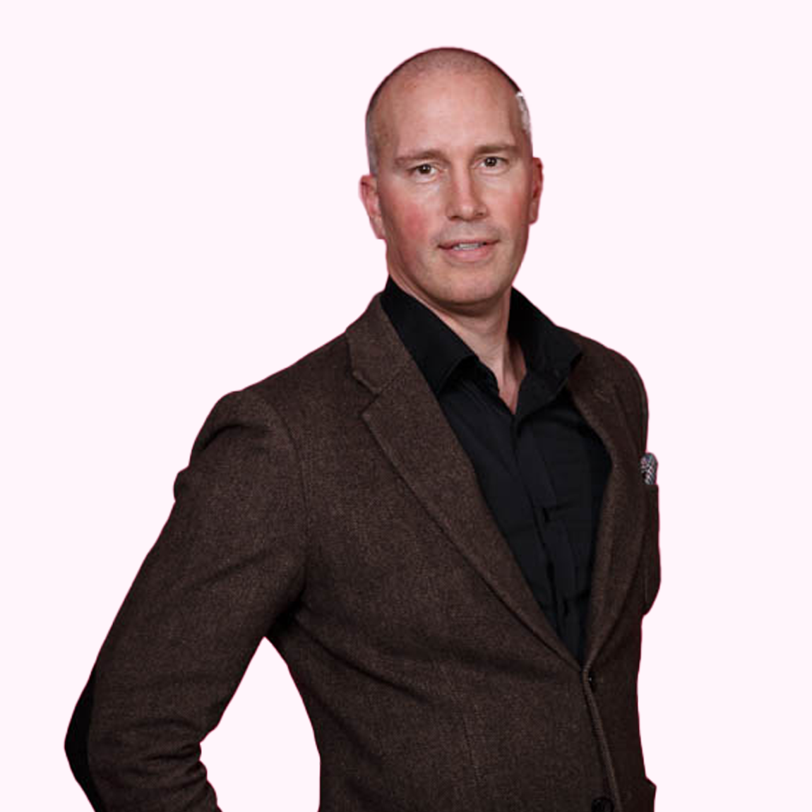 Christian Björkman, Investment Manager på Almi Invest Västsverige, står i brun kavaj och svart skjorta med ett svagt leende mot en ljusrosa bakgrund.