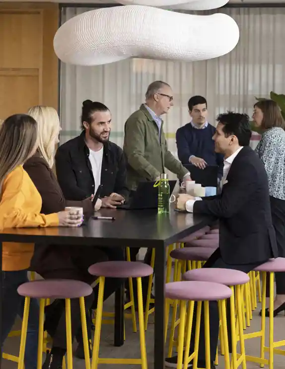 En grupp personer samtalar kring ett bord.
